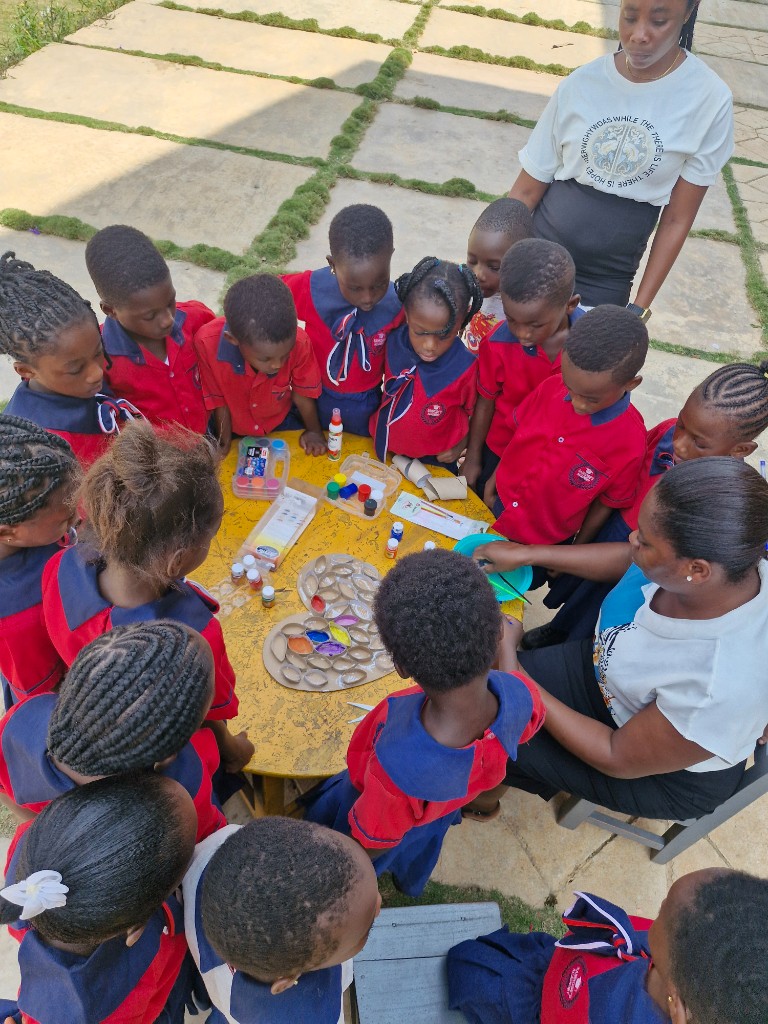Young learners gathered around a table for a painting and craft activity